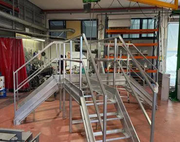 Scala in acciaio inox con doppia rampa e passerella vista frontale