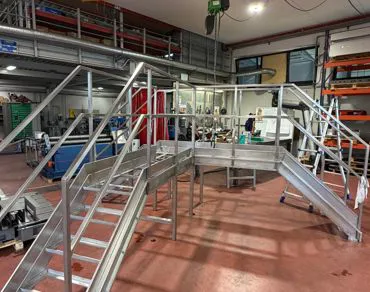Scala in acciaio inox con passerella e parapetti vista laterale